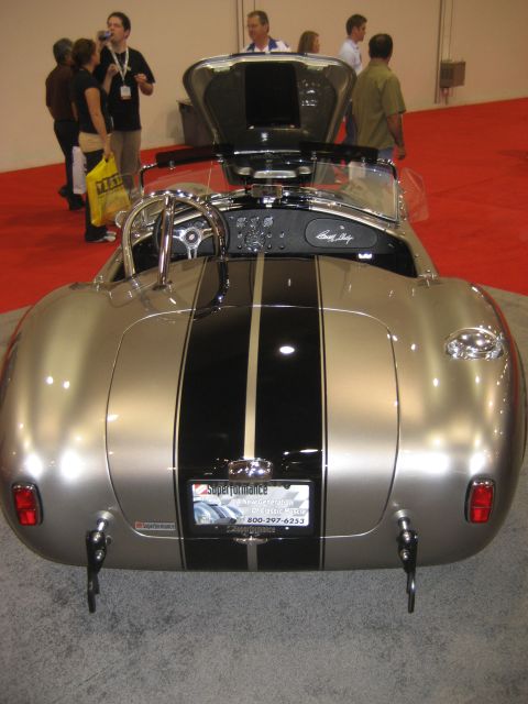1998 Ford Crown Victoria - A silver and black striped Shelby Cobra replica is displayed with its hood open, revealing the interior and steering wheel.
