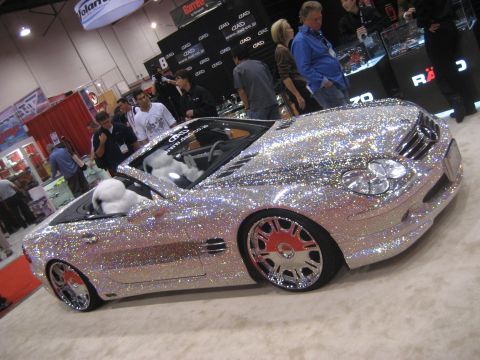 1998 Ford Crown Victoria - A highly customized convertible, covered in sparkling rhinestones, is displayed indoors.