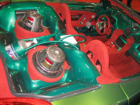 1998 Ford Crown Victoria - This custom car interior features vibrant green paint, red suede upholstery, and a powerful sound system with prominent subwoofers.