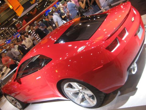 1998 Ford Crown Victoria - Red concept car on display at an auto show, with spectators in the background.