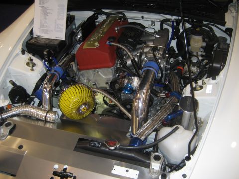1998 Ford Crown Victoria - The engine compartment of a car features custom modifications and polished components.