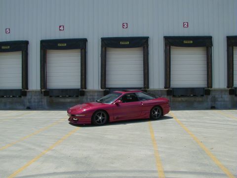 1994 Ford Probe - A red 1994 Ford Probe is parked in front of a row of loading dock doors.