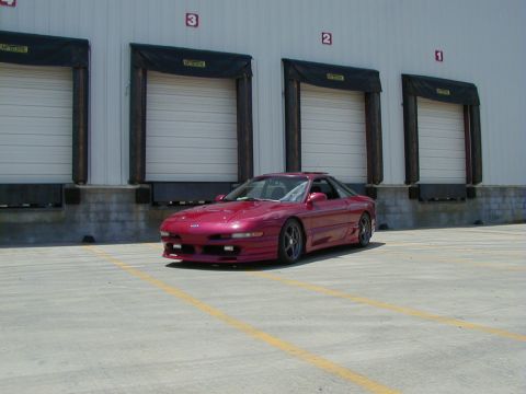 1994 Ford Probe - A red coupe is parked in front of a warehouse with loading docks numbered 1 through 4.