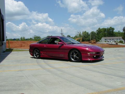 1994 Ford Probe - A red 1994 Ford Probe GT is parked outside on a sunny day with a construction site in the background.