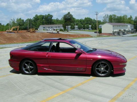 1994 Ford Probe - A red 1994 Ford Probe GT is parked on a lot with construction in the background.