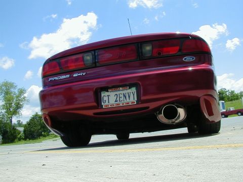 1994 Ford Probe - The rear of a red 1994 Ford Probe GT is shown with a prominent exhaust pipe and a personalized license plate.