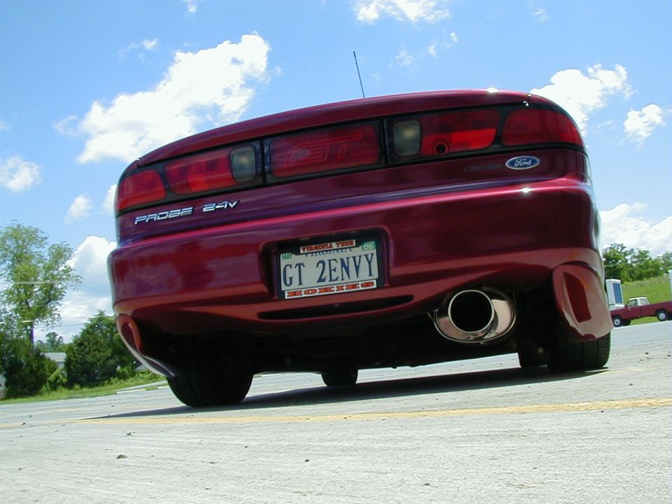 Rear view of a red 1994 Ford Probe GT with a custom exhaust and license plate reading GT 2ENVY