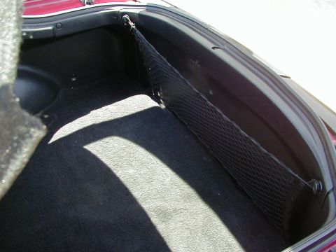 1994 Ford Probe - The interior of a car's trunk is shown, a cargo net and dark carpeting.