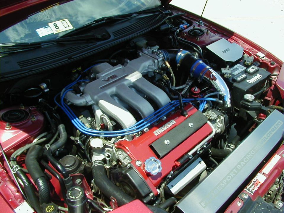 Red Mazda engine bay with V6 intake manifold and blue spark plug wires