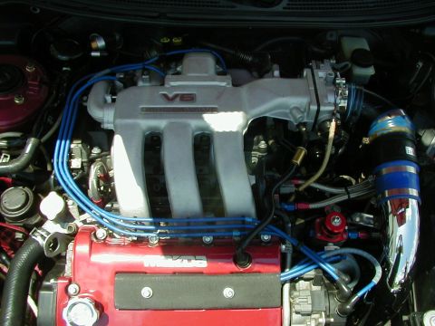 1994 Ford Probe - Close-up view of a V6 engine, a prominent intake manifold and custom blue spark plug wires.