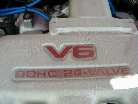 1994 Ford Probe - Close-up of an engine cover displaying V6 DOHC 24-VALVE badging, with visible blue spark plug wires.