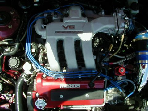 1994 Ford Probe - Close-up of an engine bay a V6 DOHC 24 valve intake manifold and a red Mazda valve cover.