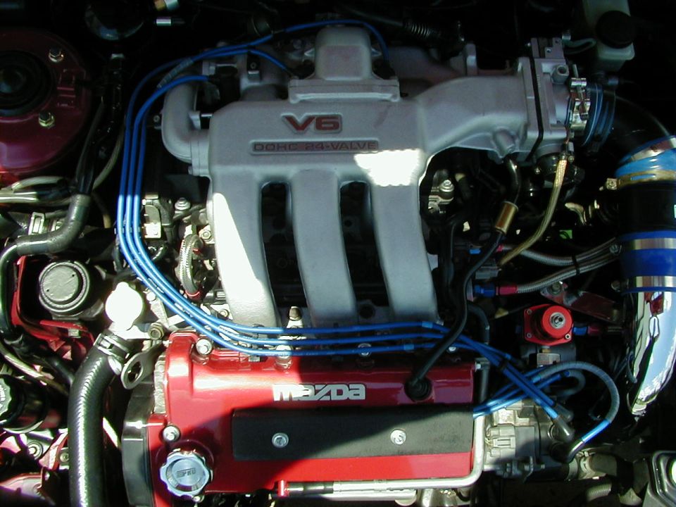 Engine bay with V6 DOHC 24 VALVE intake manifold and red Mazda valve cover