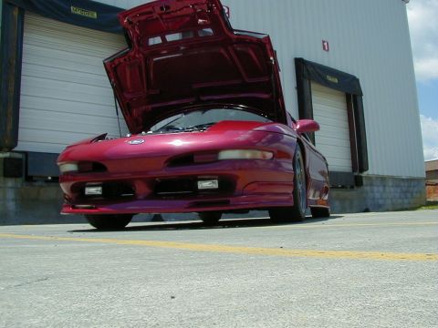 1994 Ford Probe - A red 1994 Ford Probe is parked with its hood open in front of a loading dock.