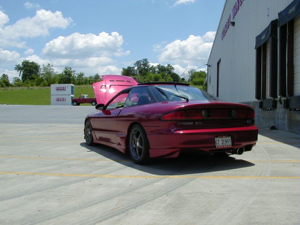 Red Ford Probe with hood up parked next to a building. License plate reads CT 2ENVY