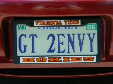 1994 Ford Probe - A red car's rear bumper displays a Virginia license plate with "GT 2ENVY" and "Virginia Tech Hokies" stickers.