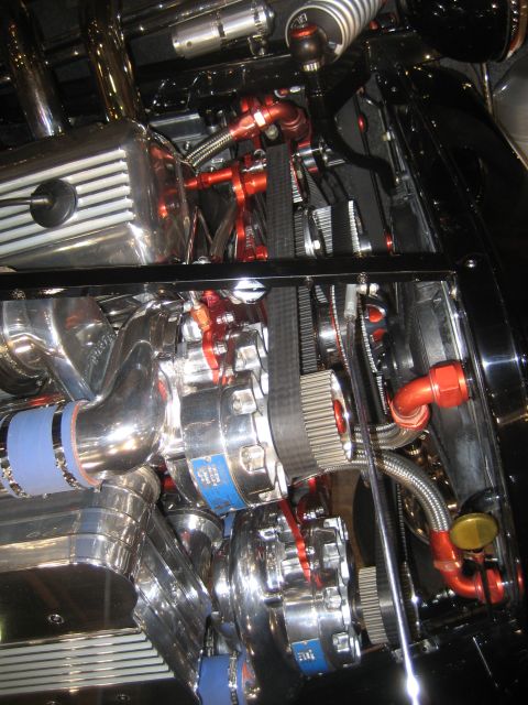 1998 Ford Crown Victoria - Close-up view of a highly customized engine bay with polished components and vibrant red accents.