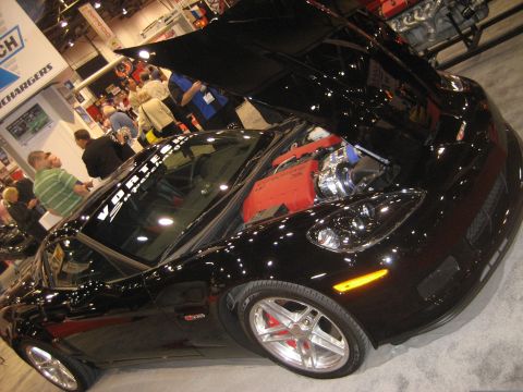 1998 Ford Crown Victoria - Black sports car on display with its hood open, showing the engine and turbocharger.