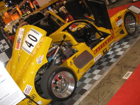 1998 Ford Crown Victoria - A yellow sports car with its doors and hood open, displaying its engine and interior details.