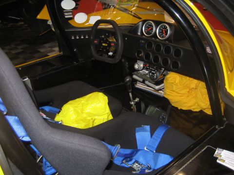 1998 Ford Crown Victoria - The interior of a race car shows racing seats, a steering wheel, and a dashboard with multiple gauges and controls.