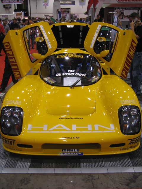 1998 Ford Crown Victoria - A yellow custom sports car with gullwing doors open is displayed, "HAHN" and "Meima GTR" branding.