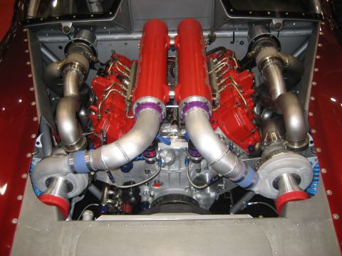 1998 Ford Crown Victoria - Close-up view of a custom twin-turbocharged V8 engine with prominent red components and polished metal piping.