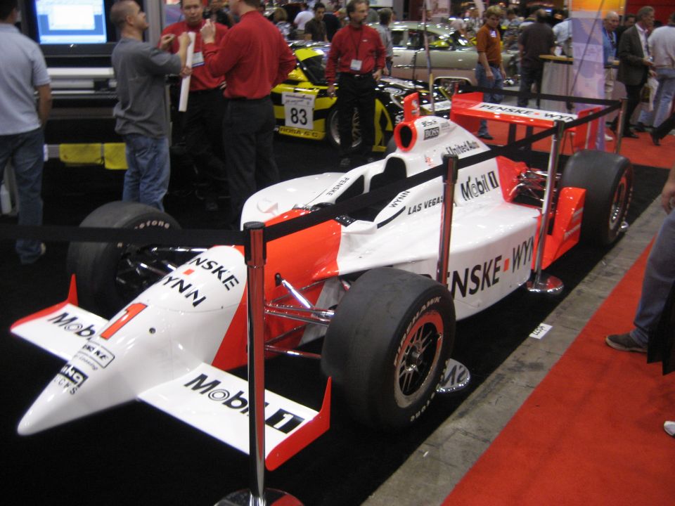 White and red Penske Indy-style open-wheel race car at a trade show