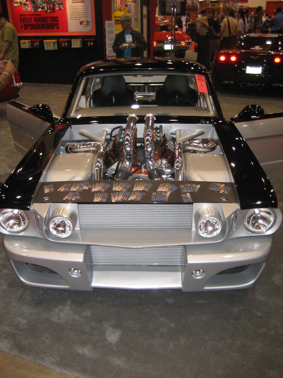 Front of silver and black custom Mustang with exposed chrome engine velocity stacks
