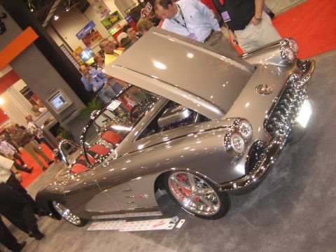 1998 Ford Crown Victoria - A customized 1958 Chevrolet Corvette is displayed with its hood open at an indoor event.
