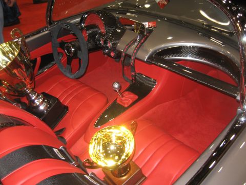 1998 Ford Crown Victoria - This custom car interior features bright red seats, trophies, and carbon fiber trim, suggesting a show car or unique build.