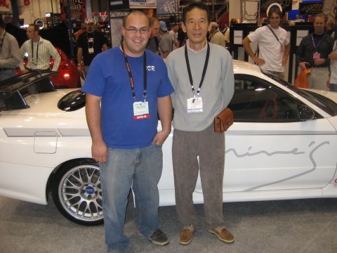 1998 Ford Crown Victoria - Two men stand beside a white sports car, which has the word 'mine's' written on its side.