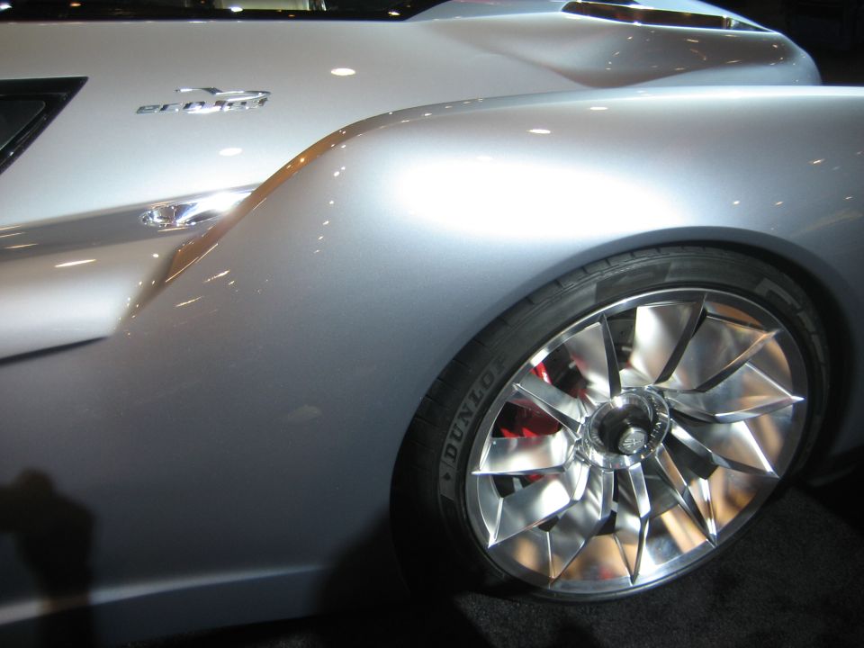 Close-up of silver concept car rear fender and turbine-style alloy wheel