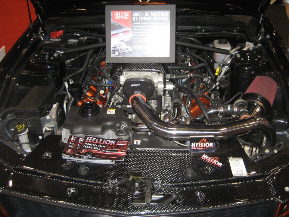 Mustang GT engine bay with Hellion turbo system and carbon-fiber cover