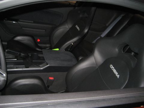 1998 Ford Crown Victoria - The interior of a car shows black Cobra racing seats and a center console.