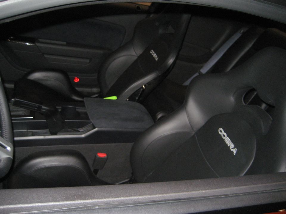 Black leather sports car interior with Cobra-embossed seats