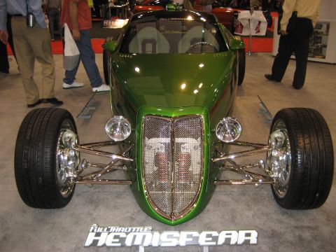 1998 Ford Crown Victoria - A custom green hot rod with a prominent grille and exposed engine is displayed indoors.