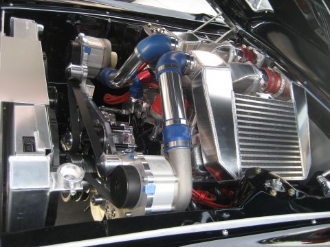 1998 Ford Crown Victoria - Close-up view of a modified engine bay a prominent supercharger and intercooler setup.