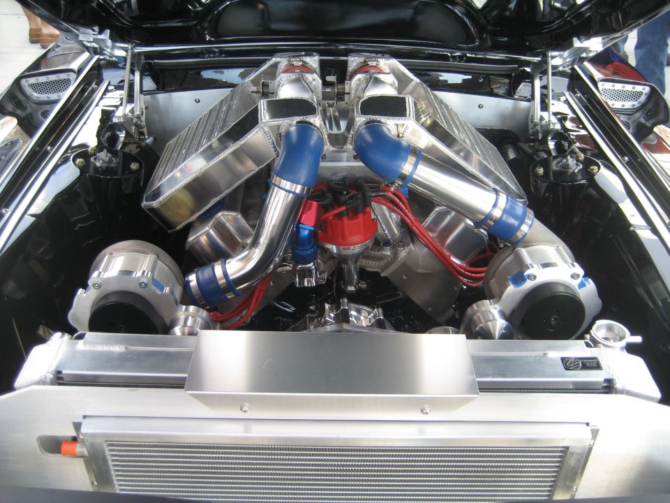 Polished twin-supercharger V8 engine with dual intercoolers and red distributor wires