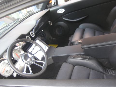 1998 Ford Crown Victoria - The interior of a modified car features a custom steering wheel and dashboard with multiple gauges.