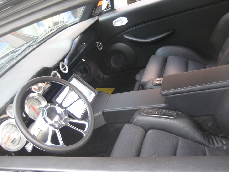 Custom black leather interior with billet steering wheel and digital gauge screen