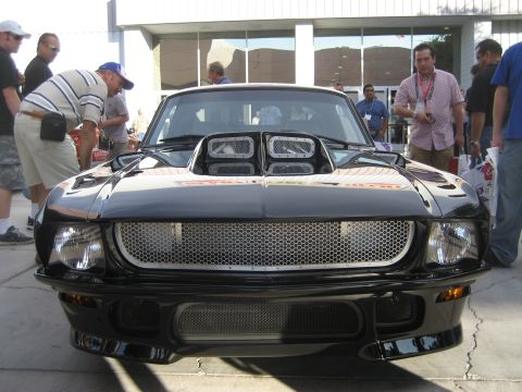 1998 Ford Crown Victoria - Front view of a black custom car a prominent hood scoop and a distinctive honeycomb grille.