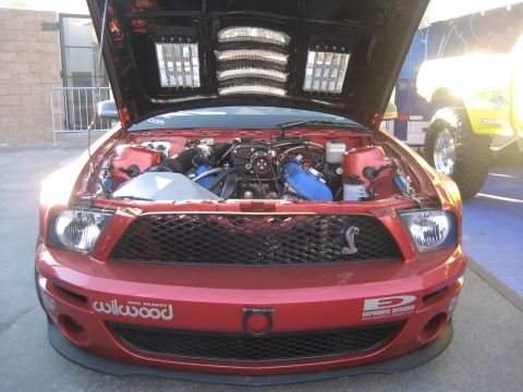1998 Ford Crown Victoria - Front view of a red Ford Mustang Shelby GT500 with its hood open, revealing the engine bay.
