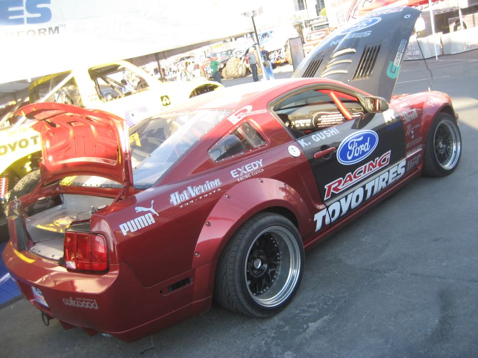 Red Ford Racing Toyo Tires drift Mustang with open hatch and roll cage
