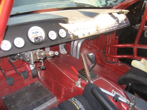 1998 Ford Crown Victoria - The interior of a modified vehicle features a roll cage, racing seats, and aftermarket gauges.
