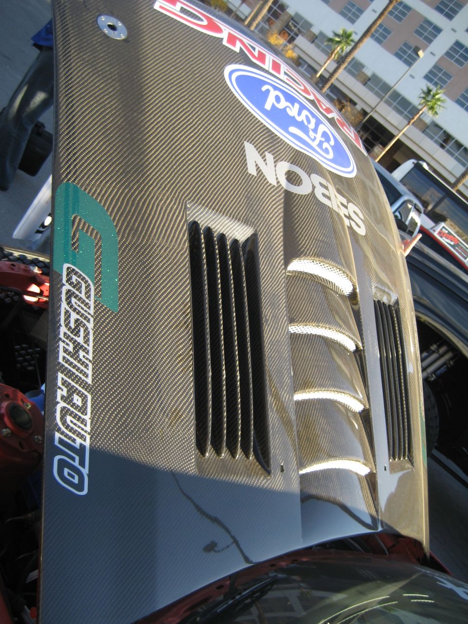 Carbon fiber hood with Ford Racing, Sabion and Crush Auto decals and louvered vents