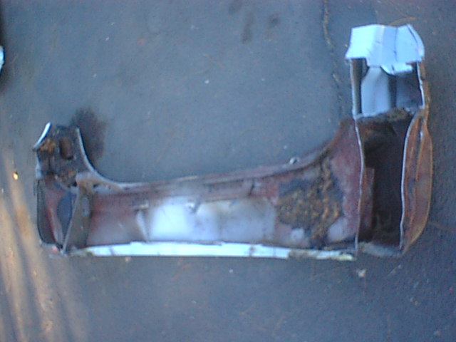 Heavily rusted automotive sheet-metal panel lying on the ground