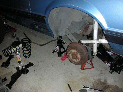1990 Ford Mustang - Suspension components and rear axle removed from a vehicle for service.