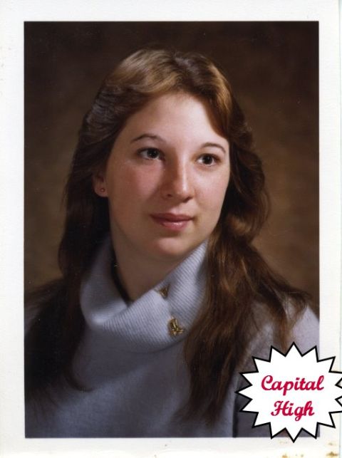 1976 Ford F-150 - A portrait of a young woman with long brown hair, wearing a light blue turtleneck sweater and a gold pin.