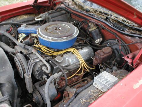 1973 Ford Ranchero - The engine bay of a 1973 Ford Ranchero shows its V8 engine, air cleaner, and various hoses and wires.