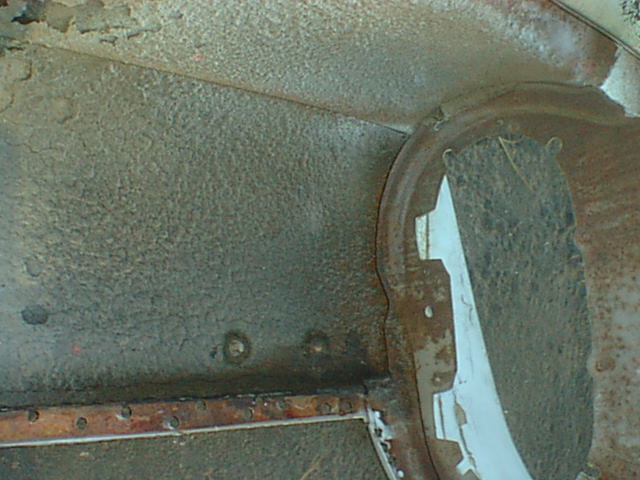 Corroded inner wheel well and floor sheet metal close-up